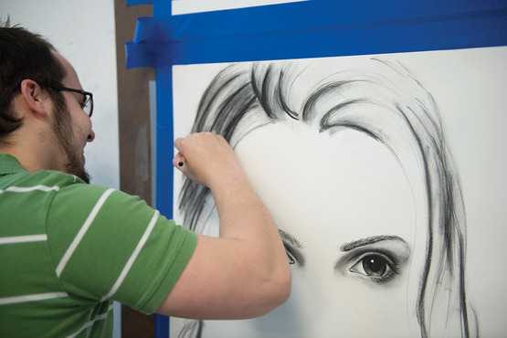 A student drawing a portrait of a woman