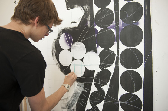 A student working on a large geometrical drawing