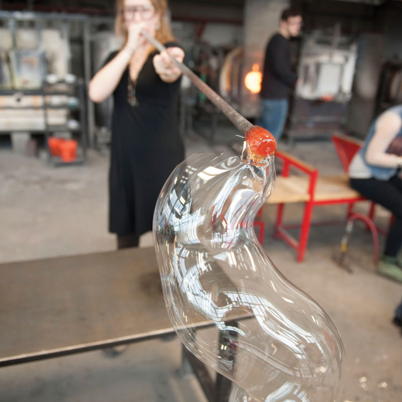 A student blowing glass
