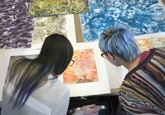 two people reviewing colorful prints
