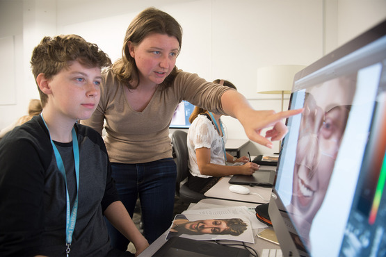 An instructor shows a student how to render on the computer in the Biomedical class. 