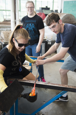 A student learns how to create a vessel in glass. 