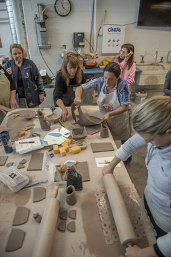 Teachers creating patterns in clay during a one-day teacher workshop. 