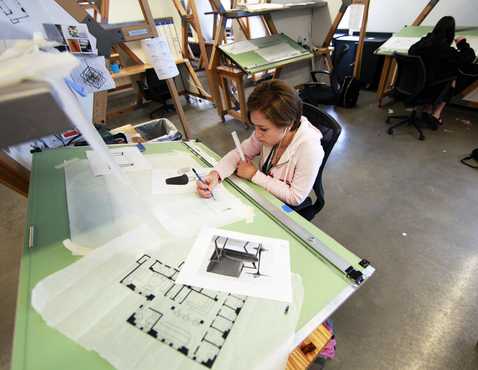 A student uses the large drafting tables in the Interior Architecture Design studio. 