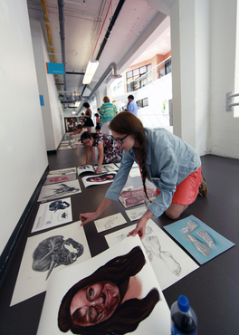 Biomedical students lay out their work and prepare for installation for the Pre-College exhibition. 