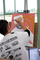 A student paints in the figure on their piece. 