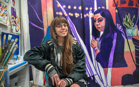 Student Rachel Moell alongside her painting in her studio