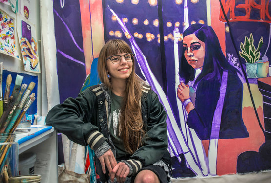 Student Rachel Moell alongside her painting in her studio